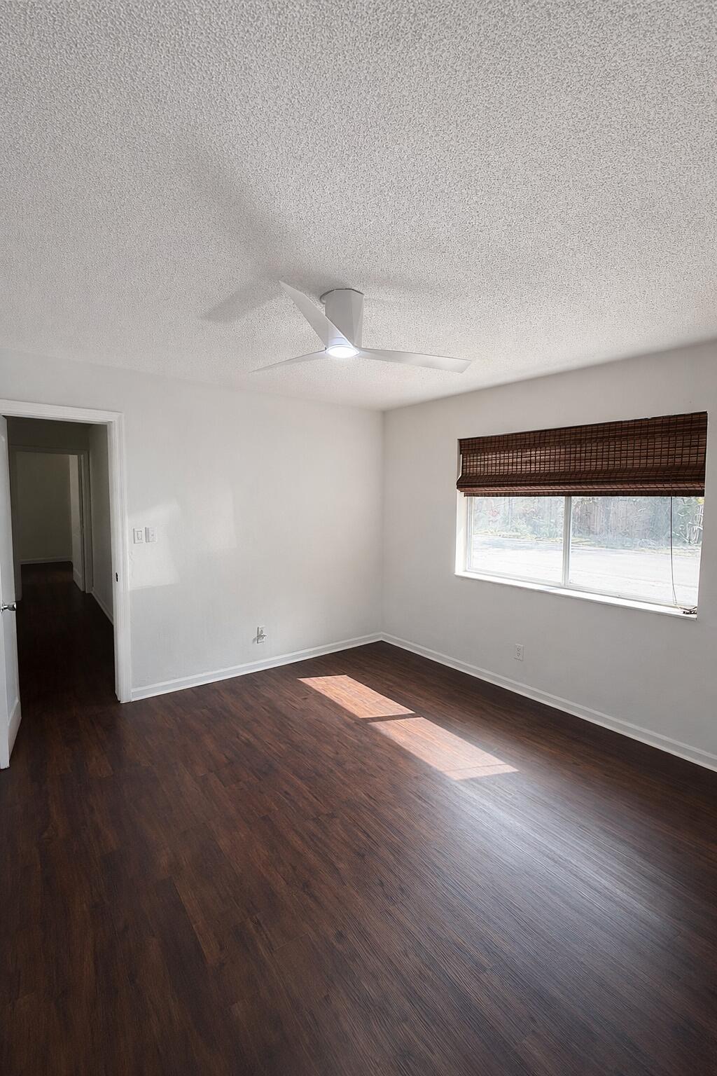 635 Southwest 14th Terrace, Unit 19 Fort Lauderdale, FL 33312 - Photo 7 of 8 an empty room with wooden floor and windows