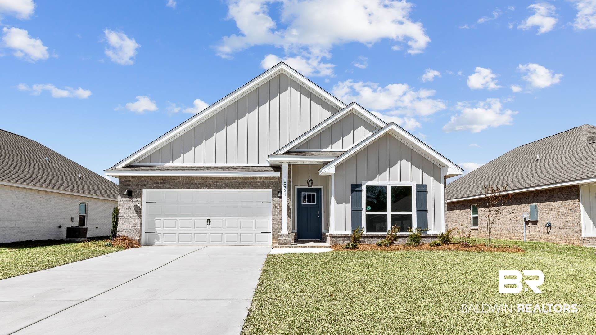 12931 Grand Rpds Road Fairhope, AL 36532 - Photo 1 of 33 View of front of property featuring a front lawn, driveway, board and batten siding, a garage, and brick siding