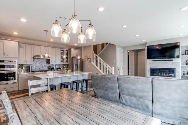 a living room with furniture flat screen tv and kitchen view