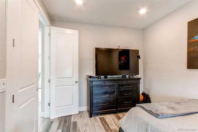 a room with a flat screen tv and dresser