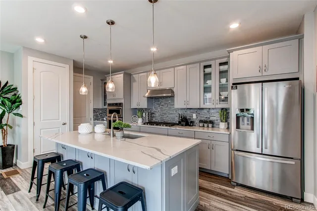 a kitchen with kitchen island a white counter space cabinets and stainless steel appliances