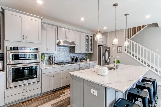 a kitchen with kitchen island a white counter top space appliances and cabinets