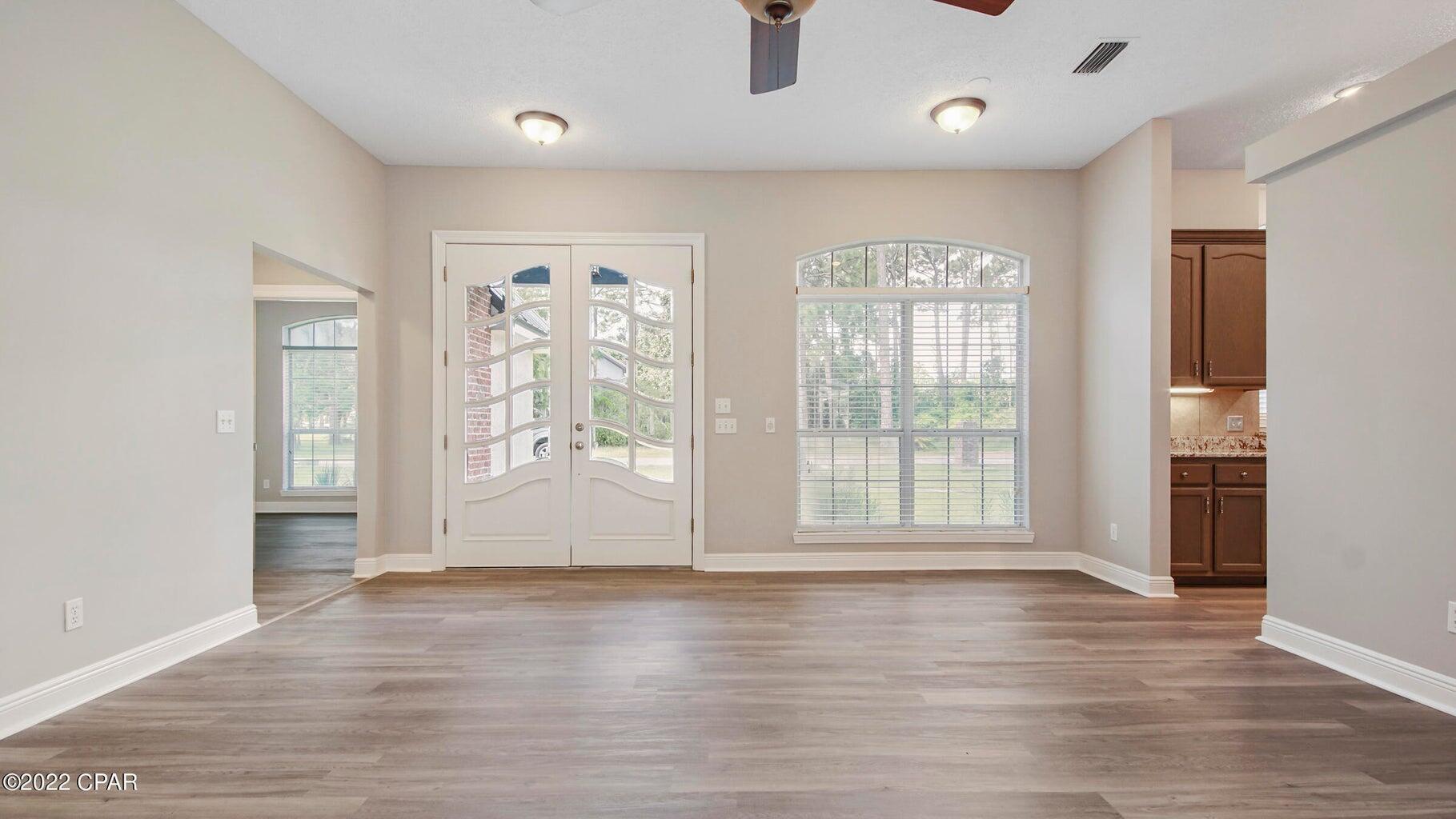 104 Colony Harbour Road Panama City Beach, FL 32407 - Photo 17 of 75 a view of an empty room with wooden floor and a window