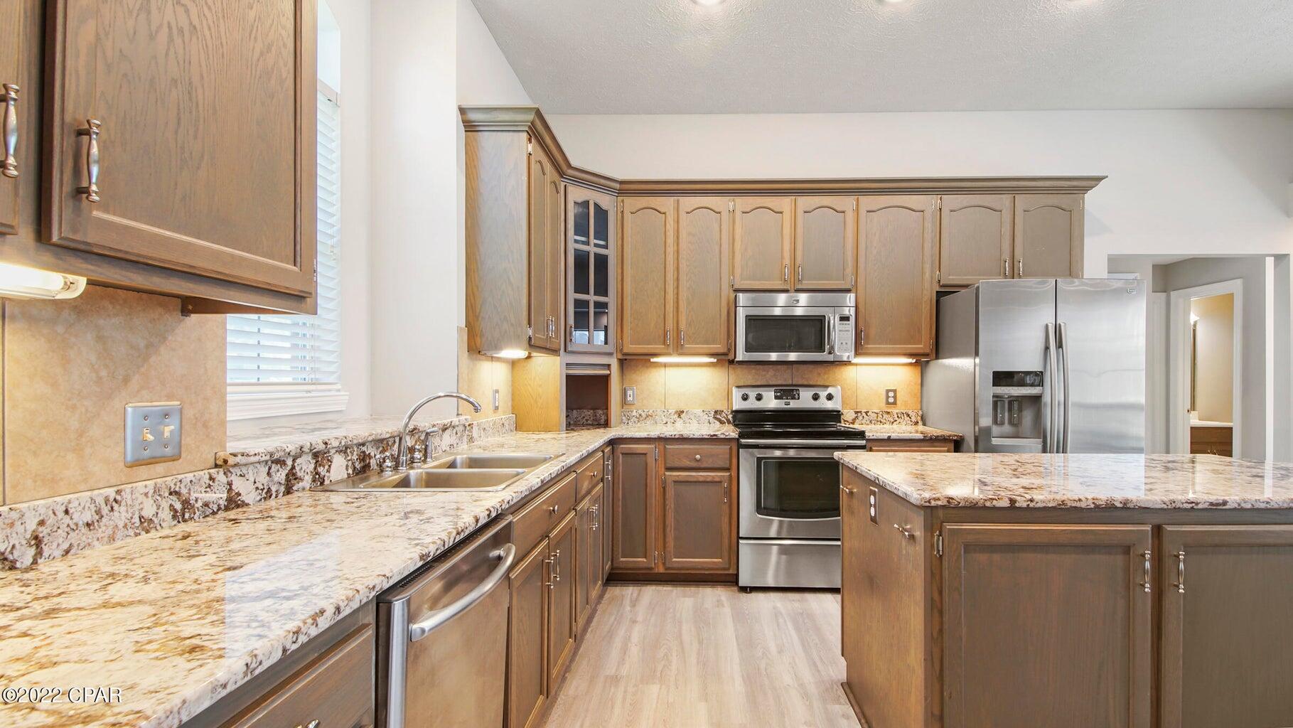 104 Colony Harbour Road Panama City Beach, FL 32407 - Photo 24 of 75 a kitchen with a sink stove and refrigerator