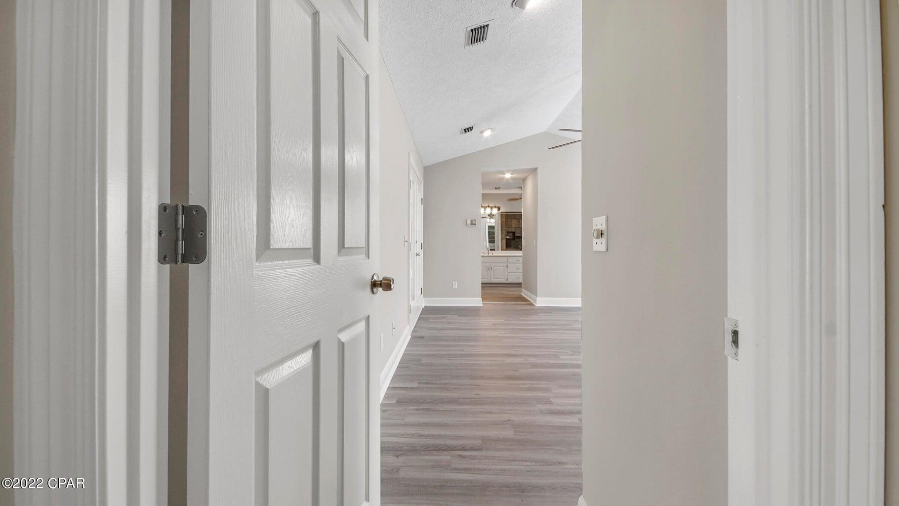 104 Colony Harbour Road Panama City Beach, FL 32407 - Photo 29 of 75 a view of a hallway with wooden floor and staircase