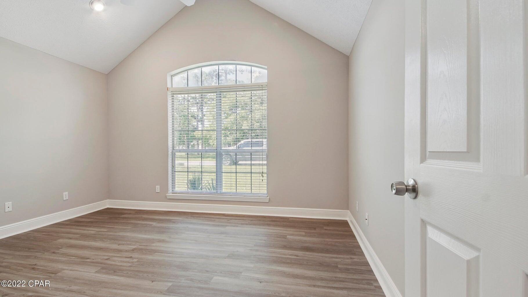 104 Colony Harbour Road Panama City Beach, FL 32407 - Photo 45 of 75 a view of an empty room with wooden floor and a window