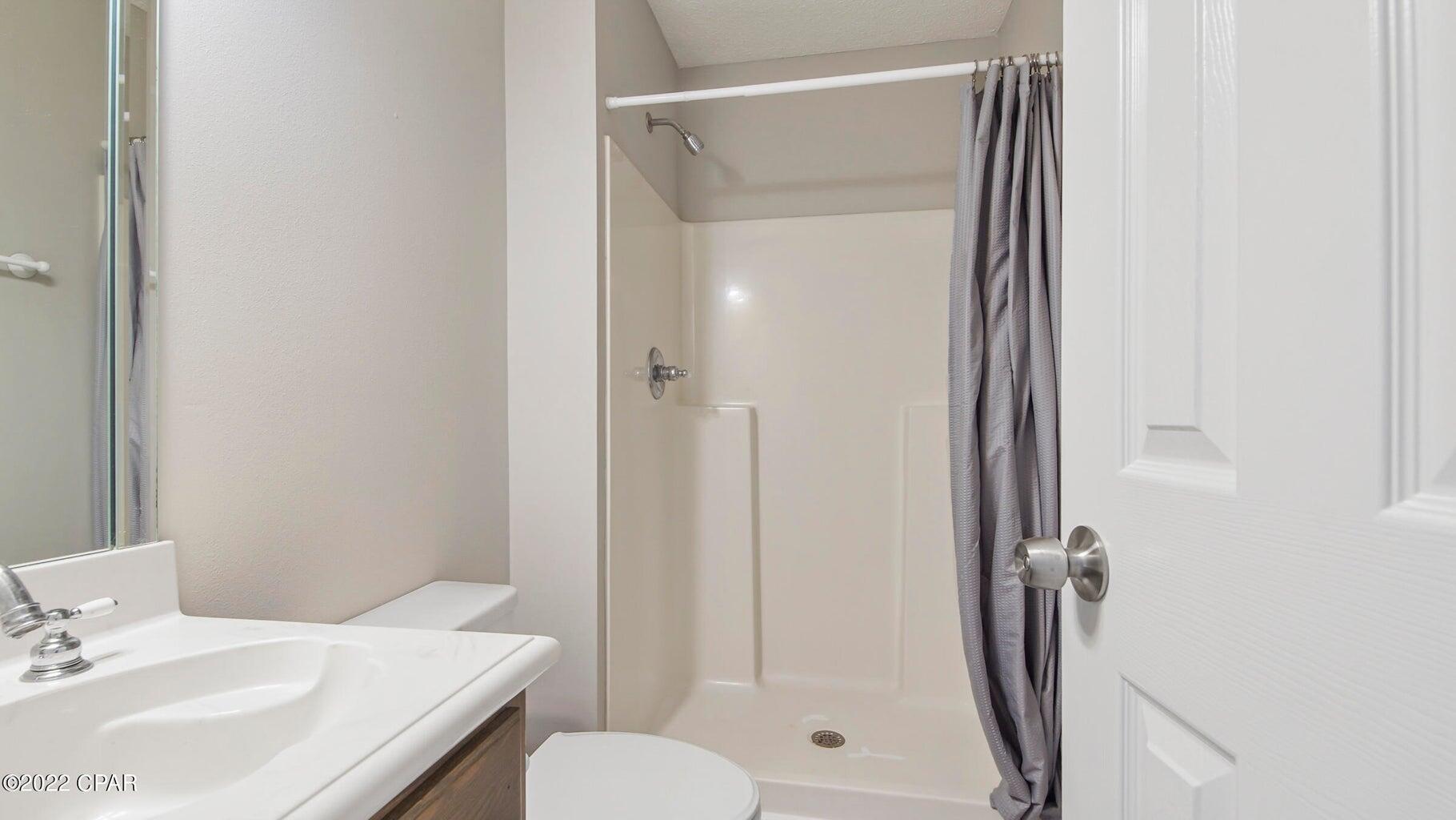 104 Colony Harbour Road Panama City Beach, FL 32407 - Photo 51 of 75 a bathroom with a shower a toilet and a sink