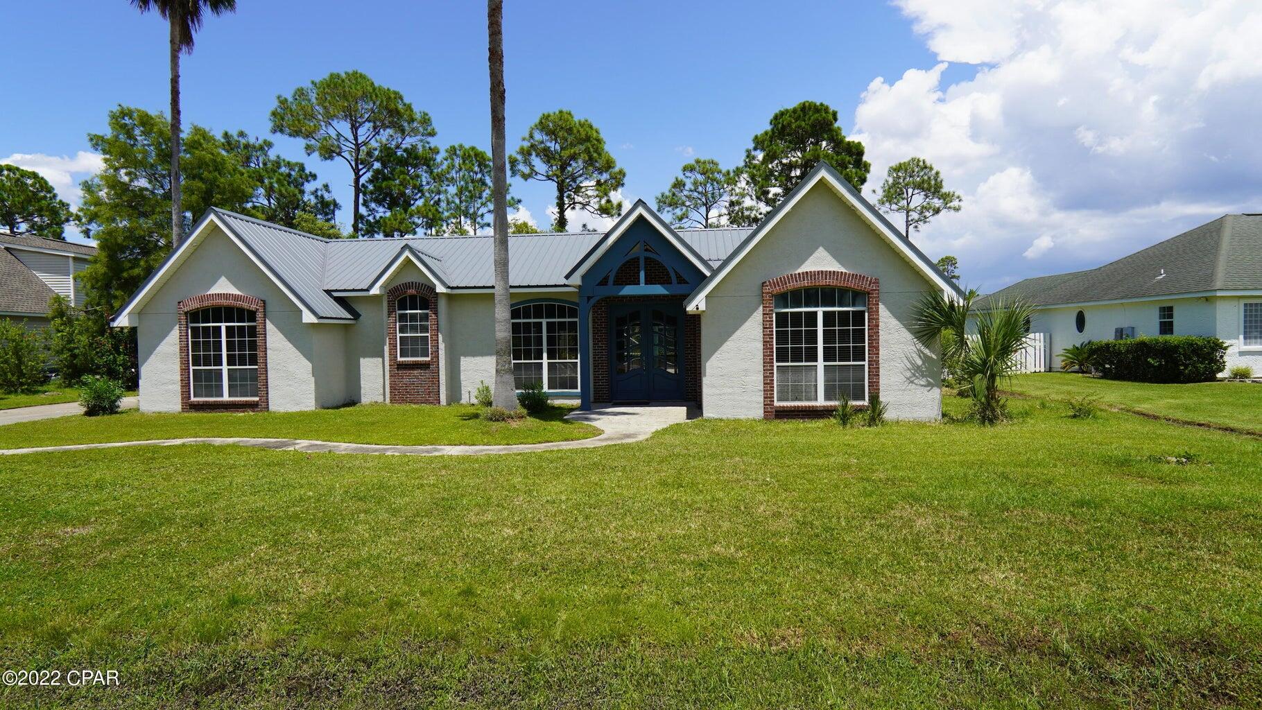 104 Colony Harbour Road Panama City Beach, FL 32407 - Photo 7 of 75 a front view of a house with a garden