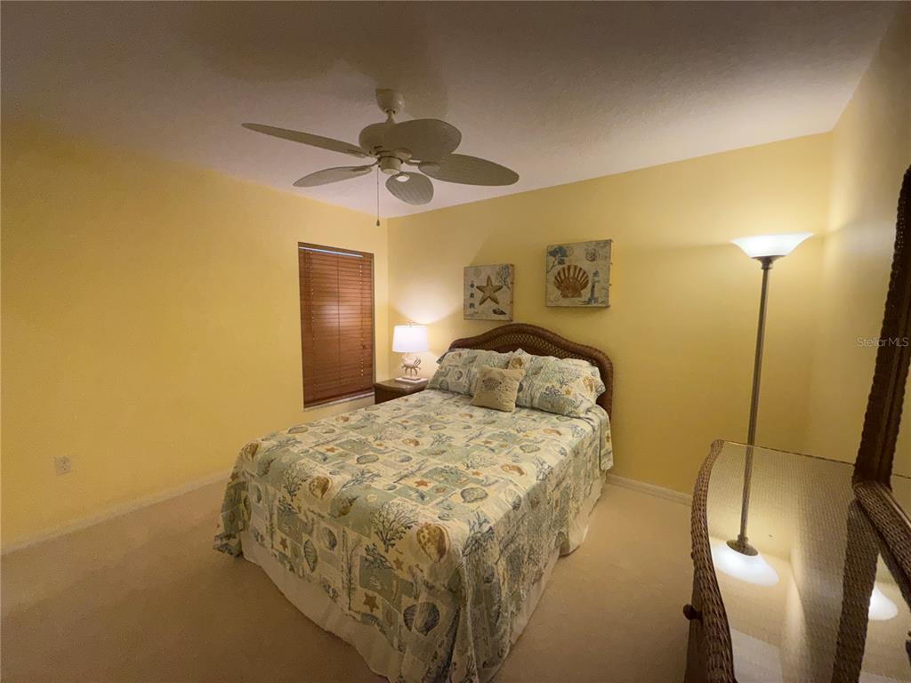 5320 Hyland Hills Avenue, Unit 2222 Sarasota, FL 34241 - Photo 19 of 29 a bedroom with a bed and a mirror