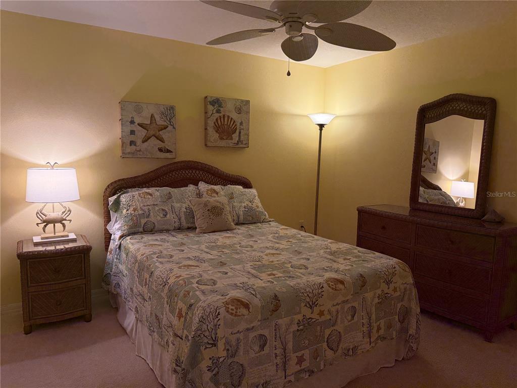 5320 Hyland Hills Avenue, Unit 2222 Sarasota, FL 34241 - Photo 20 of 29 a bedroom with a bed and a chandelier