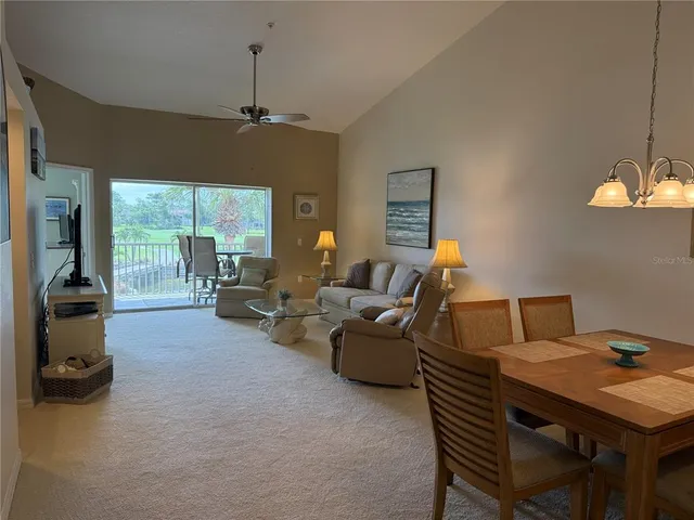 a living room with furniture a chandelier and a large window