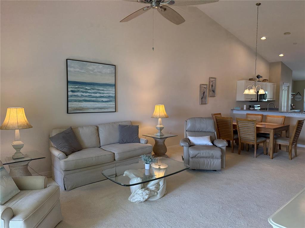5320 Hyland Hills Avenue, Unit 2222 Sarasota, FL 34241 - Photo 9 of 29 a living room with furniture and a lamp