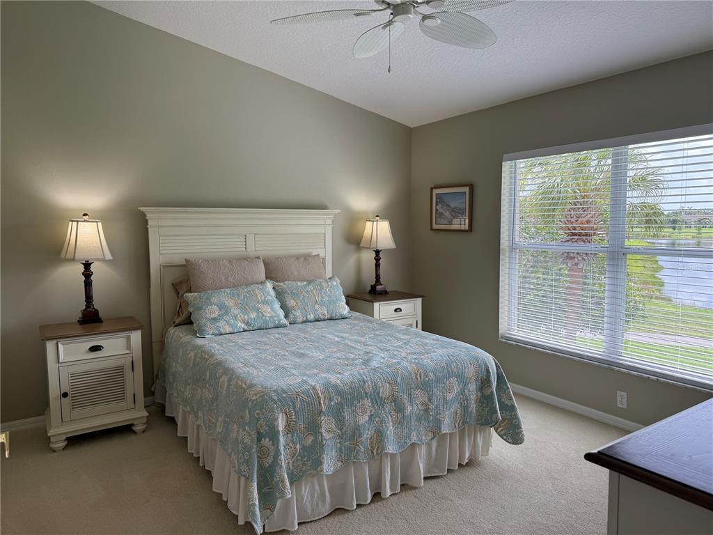 5320 Hyland Hills Avenue, Unit 2222 Sarasota, FL 34241 - Photo 10 of 29 a bedroom with a bed and a chandelier