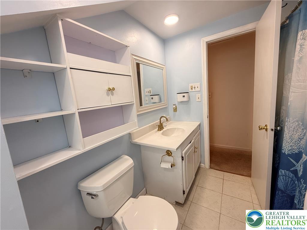 170 Springhouse Road Allentown, PA 18104 - Photo 16 of 23 A compact bathroom featuring built-in shelving, a single vanity, and tiled flooring for practical living.