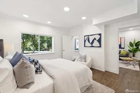 a bedroom with a large bed and a potted plant