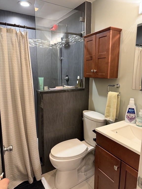 32 Fleet Street, Unit B Boston, MA 02113 - Photo 7 of 7 a bathroom with a sink a toilet a mirror and shower curtain