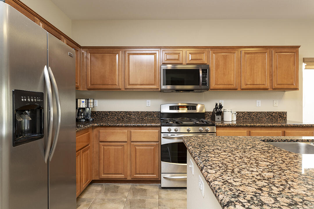 1280 Oro Ridge Palm Springs, CA 92262 - Photo 12 of 46 a kitchen with stainless steel appliances granite countertop a refrigerator stove and microwave