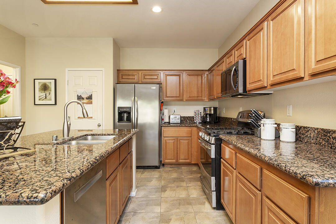 1280 Oro Ridge Palm Springs, CA 92262 - Photo 13 of 46 a kitchen with stainless steel appliances granite countertop a sink stove and refrigerator