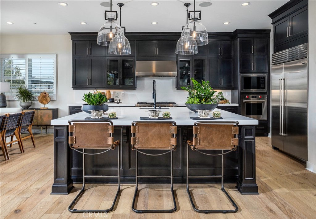 27534 Elderberry Drive Valencia, CA 91381 - Photo 6 of 17 a kitchen with granite countertop a table chairs stove and refrigerator