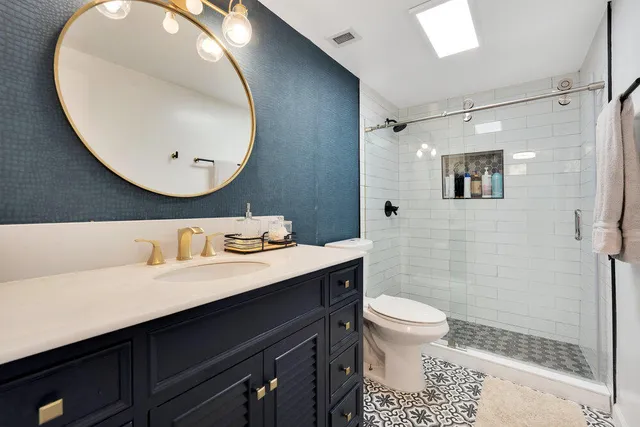 a bathroom with a sink a toilet and a mirror