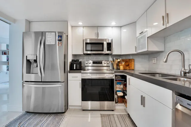 a kitchen with stainless steel appliances a refrigerator sink and microwave