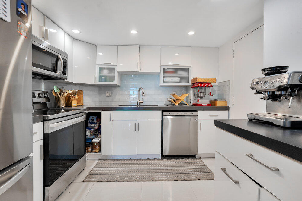500 Bayview Drive, Unit 1521 Sunny Isles Beach, FL 33160 - Photo 8 of 31 a kitchen with white cabinets and appliances