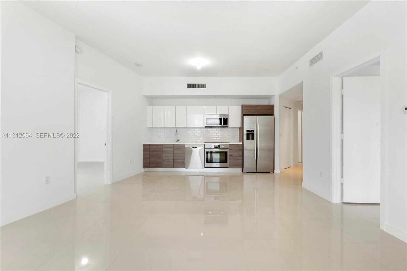 1010 Southwest 2nd Avenue, Unit 2004 Miami, FL 33130 - Photo 1 of 19 a view of a kitchen with a sink and dishwasher a refrigerator with white cabinets