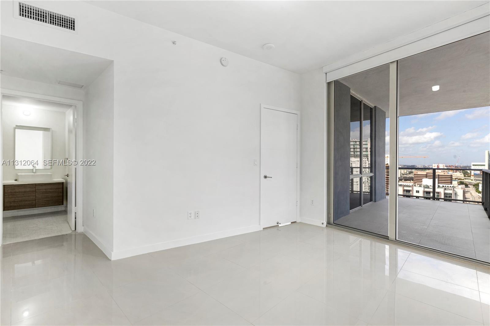 1010 Southwest 2nd Avenue, Unit 2004 Miami, FL 33130 - Photo 8 of 19 an empty room with sliding door and mirror