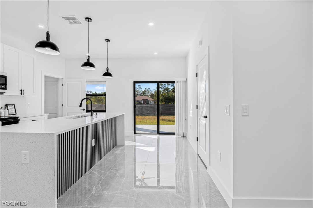 745 Roma Avenue South Lehigh Acres, FL 33974 - Photo 21 of 40 a large kitchen with a lot of cabinets and glass door