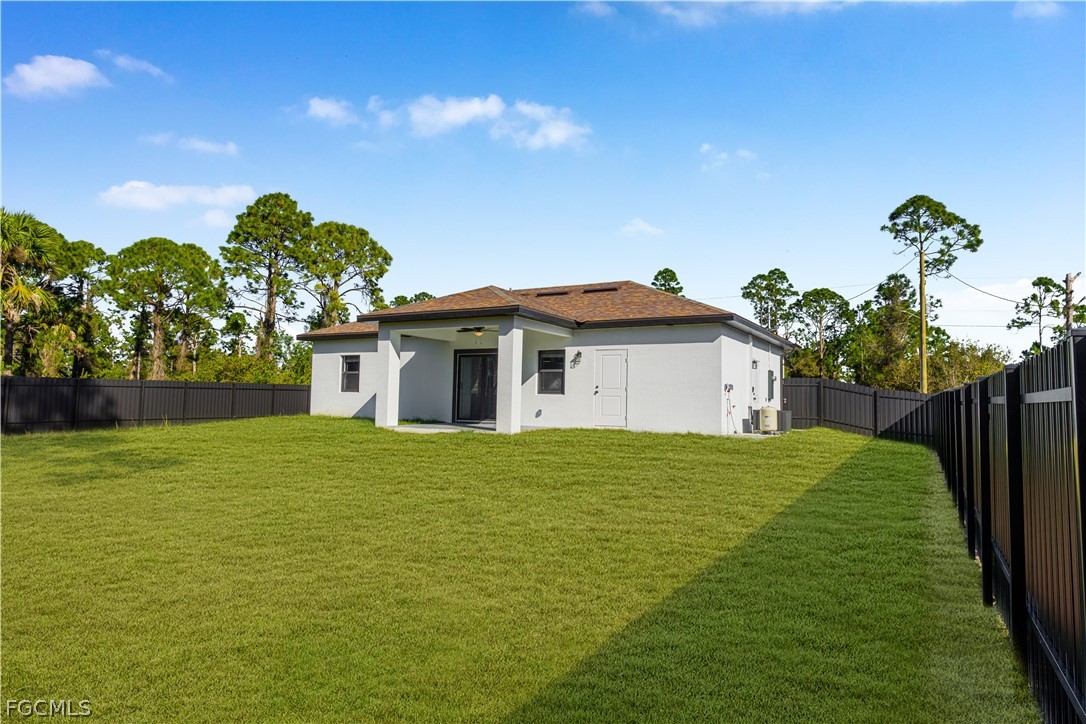 745 Roma Avenue South Lehigh Acres, FL 33974 - Photo 39 of 40 a yellow house with garden in front of it