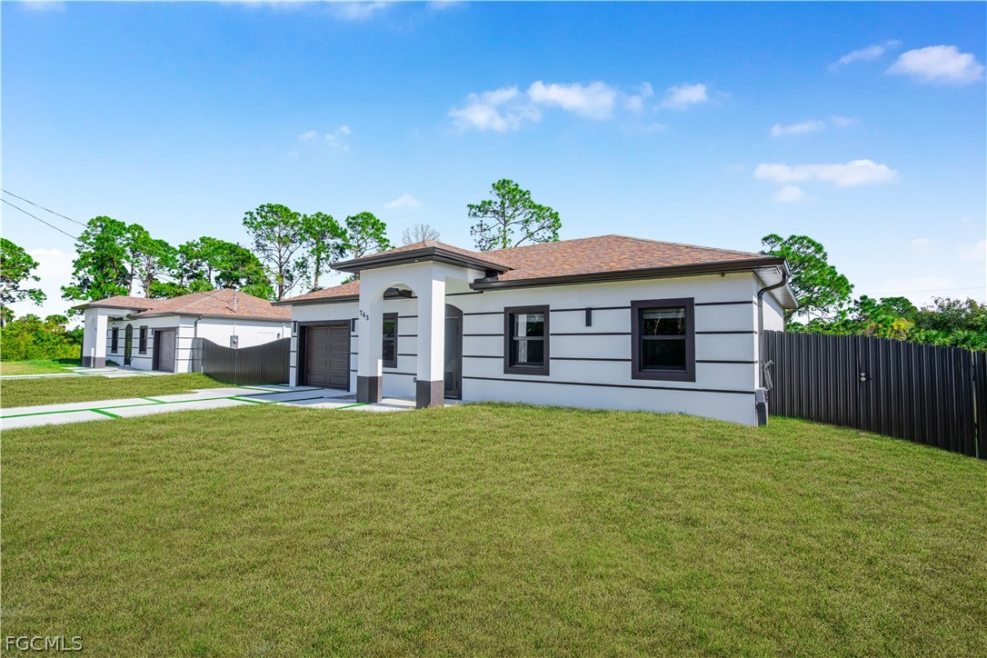 745 Roma Avenue South Lehigh Acres, FL 33974 - Photo 4 of 40 a front view of a house with a garden and yard