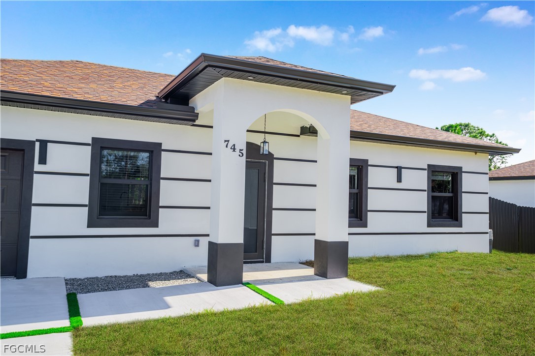 745 Roma Avenue South Lehigh Acres, FL 33974 - Photo 5 of 40 a front view of a house with a yard