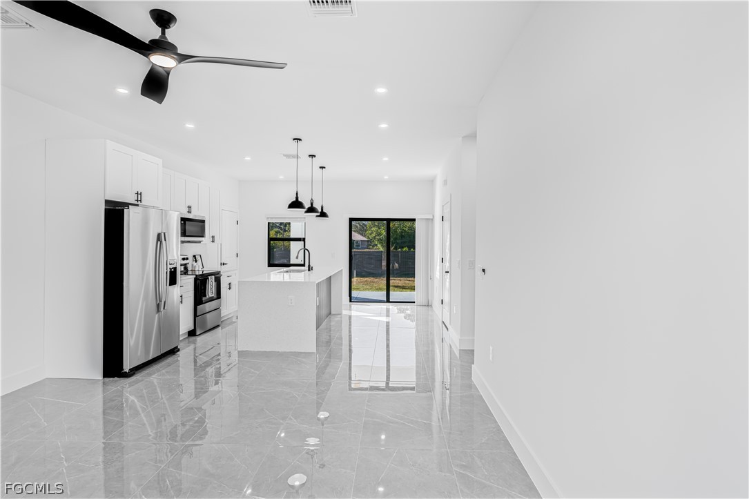 745 Roma Avenue South Lehigh Acres, FL 33974 - Photo 6 of 40 a view of a kitchen with refrigerator and windows