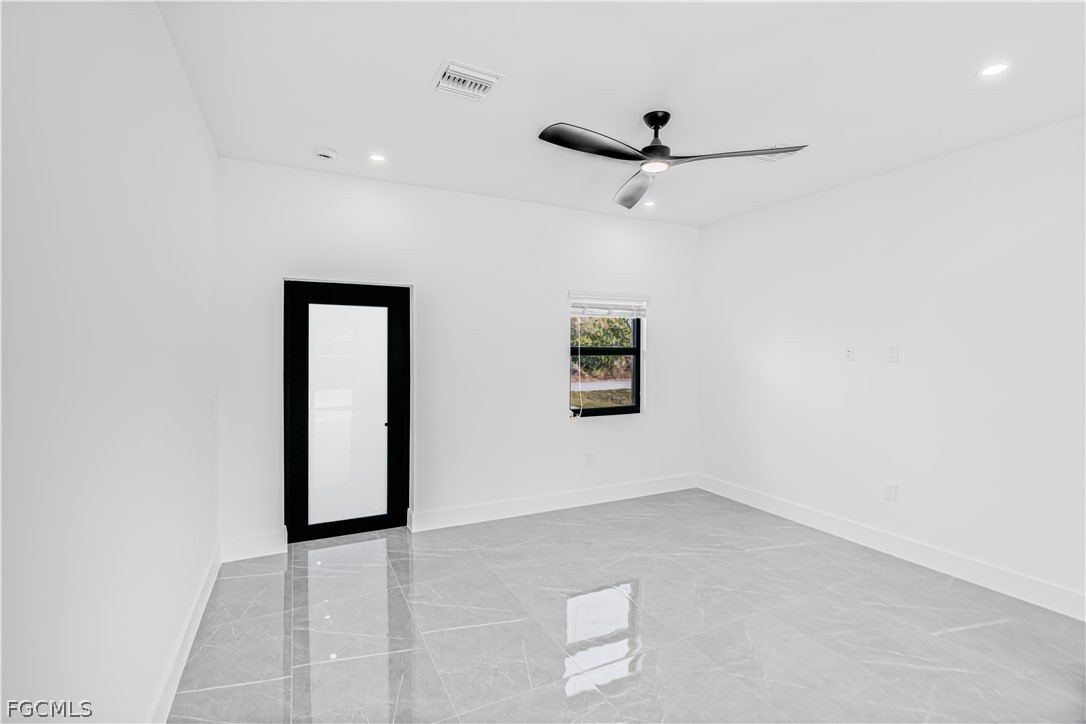 745 Roma Avenue South Lehigh Acres, FL 33974 - Photo 9 of 40 an empty room with a ceiling fan and carpet