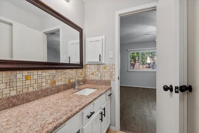 a bathroom with a granite countertop sink and a mirror