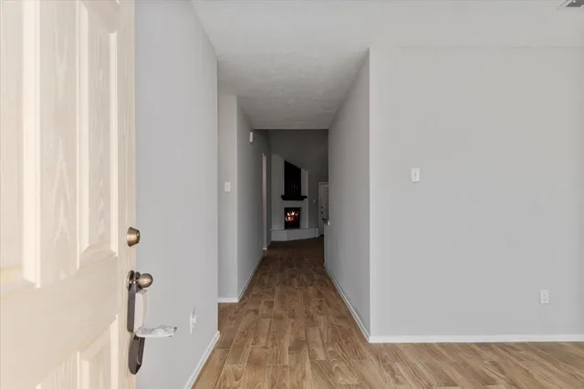 a view of a hallway with wooden floor and staircase