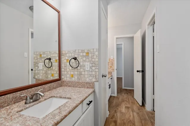 a bathroom with a granite countertop sink a mirror and a shower