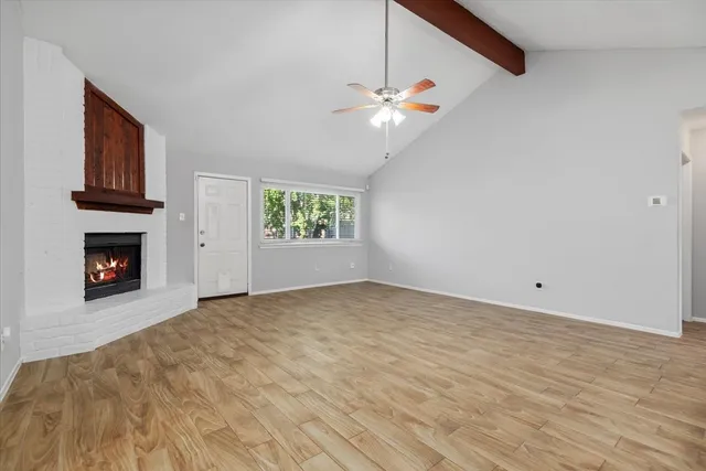 a view of an empty room with a fireplace and a window