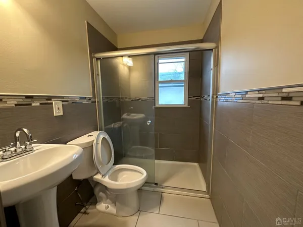 a bathroom with a toilet a sink and shower