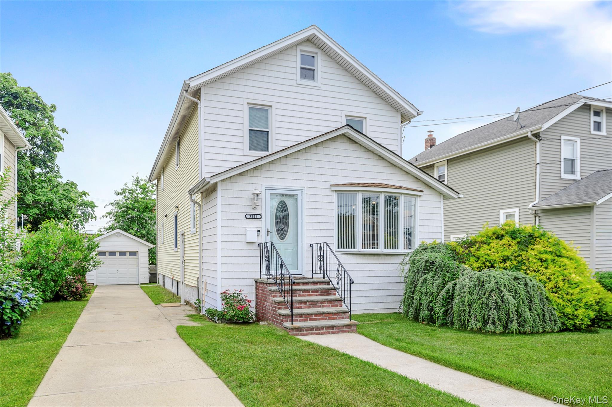 3124 Ralph Avenue Oceanside, NY 11572 - Photo 1 of 13 a front view of a house with a garden