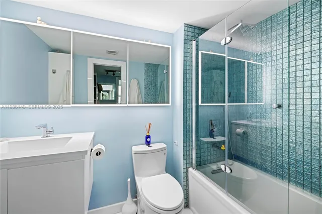 a bathroom with a sink mirror toilet and bathtub