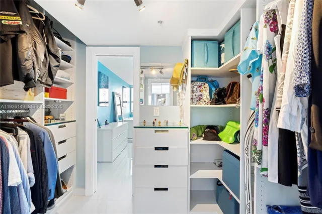 a view of walk in closet with clothes and shoes