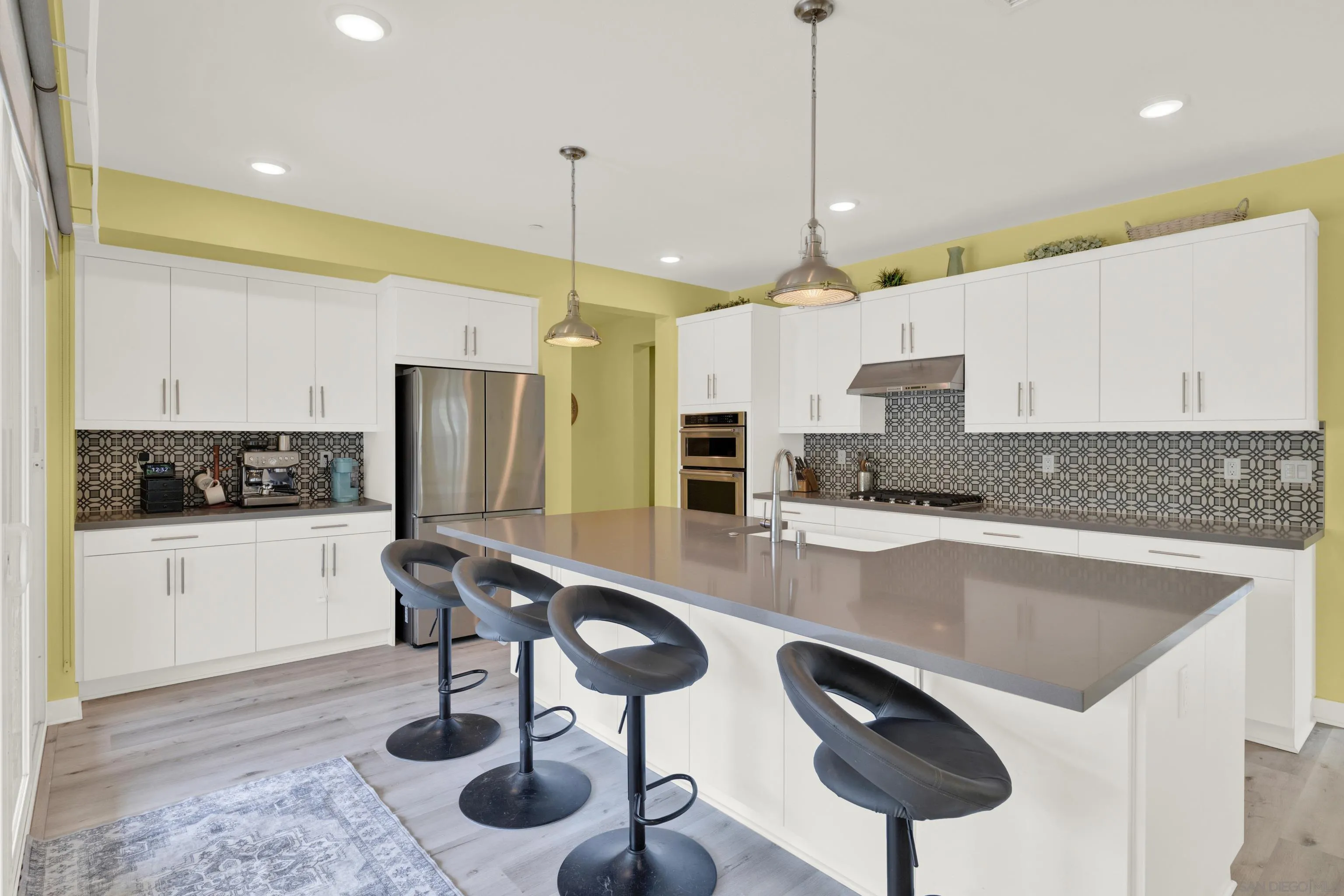 9108 West Bluff Place Santee, CA 92071 - Photo 32 of 72 a kitchen with stainless steel appliances granite countertop a sink a stove a refrigerator and chairs