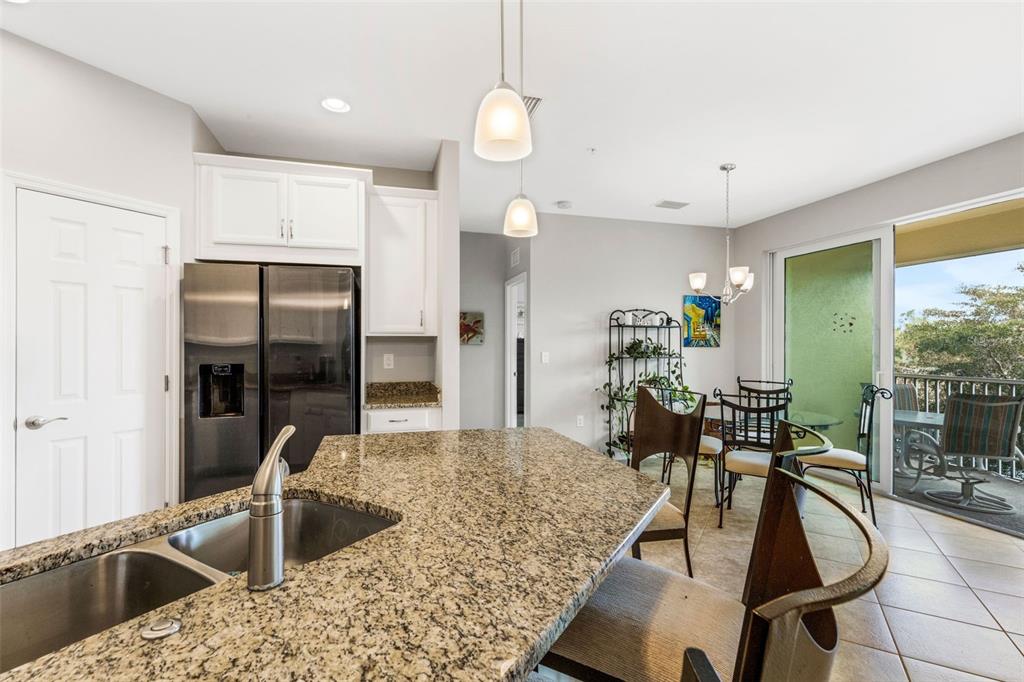 4284 Expedition Way Osprey, FL 34229 - Photo 11 of 40 a kitchen with stainless steel appliances granite countertop a sink refrigerator and cabinets