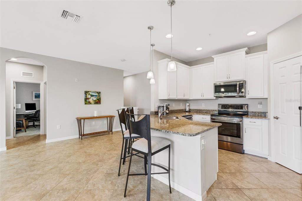 4284 Expedition Way Osprey, FL 34229 - Photo 12 of 40 a kitchen with a stove a refrigerator and a microwave