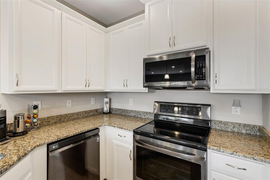 4284 Expedition Way Osprey, FL 34229 - Photo 13 of 40 a kitchen with granite countertop white cabinets and stainless steel appliances