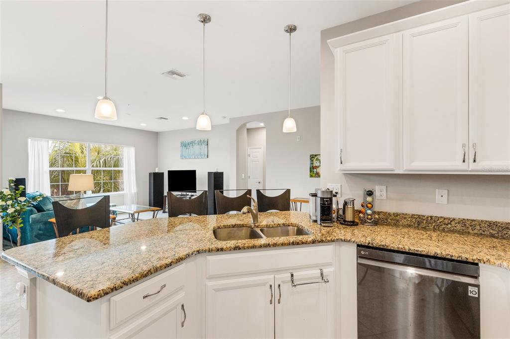 4284 Expedition Way Osprey, FL 34229 - Photo 14 of 40 a kitchen with granite countertop a sink and white cabinets