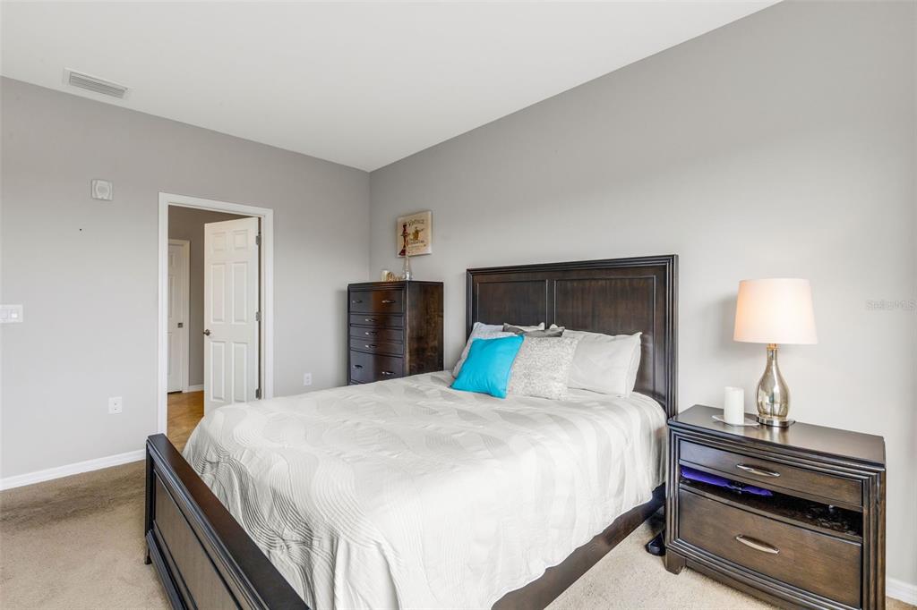 4284 Expedition Way Osprey, FL 34229 - Photo 19 of 40 a bedroom with a bed and a lamp on table