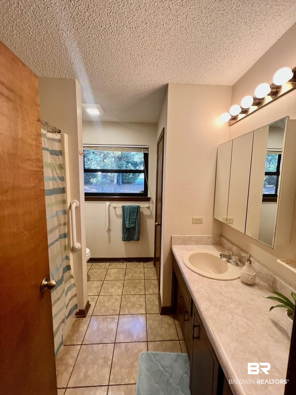 2682 Pine Ridge Drive Lillian, AL 36549 - Photo 13 of 37 Bathroom featuring tile patterned floors, plenty of natural light, toilet, and a textured ceiling