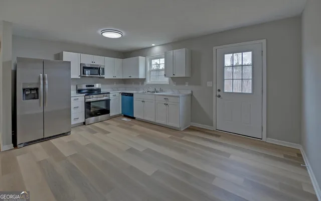 a kitchen with granite countertop a refrigerator stove top oven and sink
